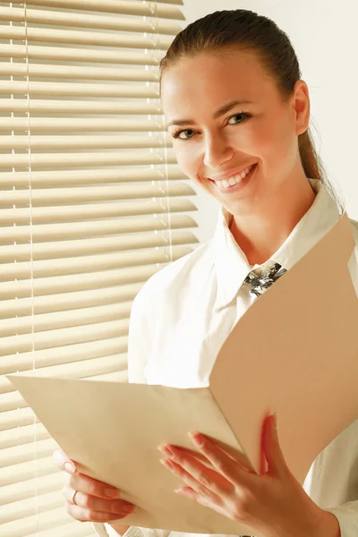 Woman is standing with folder — Stockfoto