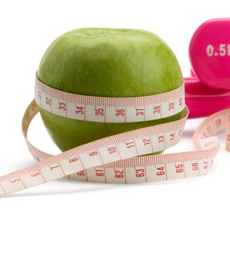 bir elma, bir ölçüm bandı ve dumbbell