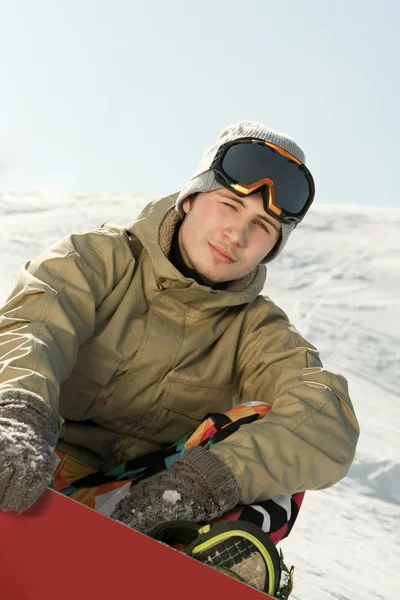 Snowboarder sentado em uma pista de esqui — Fotografia de Stock