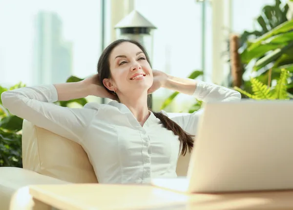 Bella donna felice seduta con computer portatile — Foto Stock