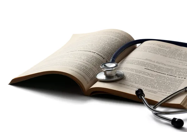 Een stethoscoop is liggend op een open boek — Stockfoto