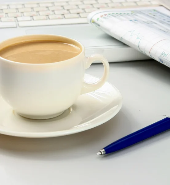 Tasse de café près de l'ordinateur portable et des journaux — Photo