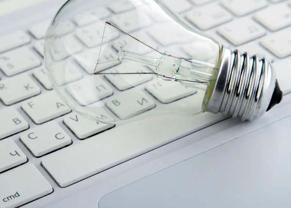 Light bulb and computer keyboard — Stock Photo, Image