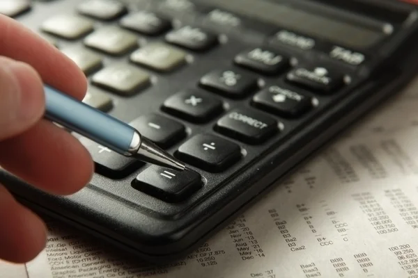 Pen and calculator on paper — Stock Photo, Image