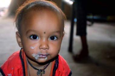 Hintli kırsal anne, 10 aylık bebeğini kaşıkla besliyor, çocuk için ilk katı yiyecek, seçici odaklanma.