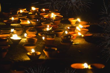 Geleneksel kil diya lambaları Diwali kutlaması sırasında yanar, arka planda havai fişekler Mutlu Diwali - Gece sokakta aydınlatma lambası
