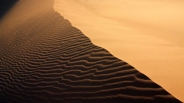 Zand textuur met licht en schaduwen en wind-gemaakt golven in erg chigaga, Marokko — Stockfoto