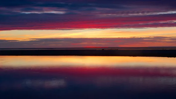 Wunderschöner blauer und roter Sonnenuntergang in Kalajoki, der sich im Meer spiegelt — Stockfoto