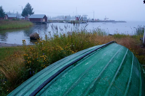 Kterým malý dřevěný člun se převrátil na trávě vedle pláže — Stock fotografie