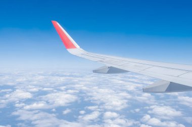 Airplane wing, Clouds and blue sky has seen through the window of an aircraft view.