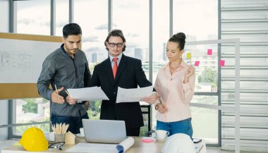 Engineer team is meeting to inspect the construction blueprint drawings, work plan and distribute work before starting the building.