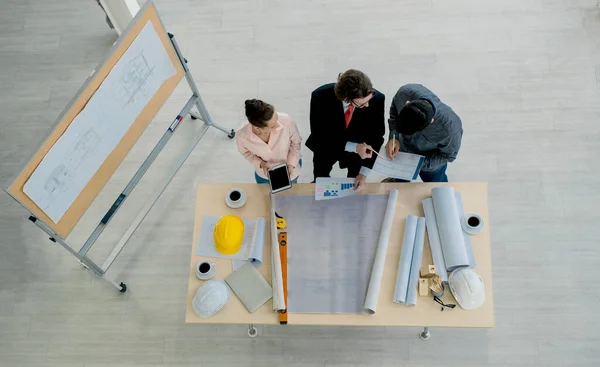 Top view of Engineer team is meeting to inspect the construction blueprint drawings, work plan and distribute work before starting the building