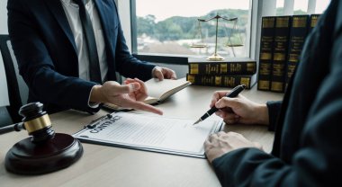 Businesswoman hand sign after Lawyer providing legal consult dispute service at the office with justice scale and gavel hammer.