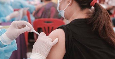 medical doctor hand has coronavirus covid vaccinate to fat Asia senior woman at a field hospitel, a place set up by the government.