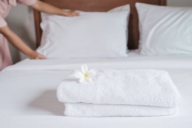 towels and Plumeria on the bed in the luxury hotel room ready for tourist travel.