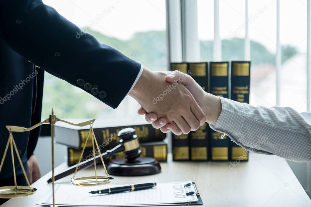 Handshake after Lawyer  providing legal consult business dispute service to the man at the office with justice scale and gavel hammer.