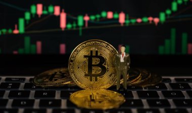 Bitcoin businessman toy and stock exchange graph background. Risk and wealth can happen in investment savings or trading in cryptocurrency innovation.