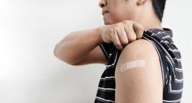 Asia man showing shoulder with bandage has gone to vaccinate coronavirus covid19, Healthcare And Inoculation Concept.