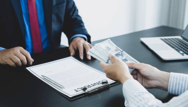 Businessman hand bribe the money to the government official sign the contract, the concept of corruption and anti-bribery.