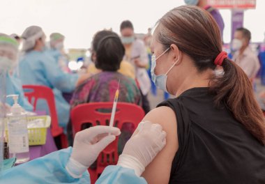 Fat Asia senior woman has gone to vaccinate coronavirus covid19 with medical staff in a field hospitel. a place set up by the government.