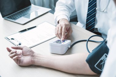 The man doctor hand use the pulse meter to measure the pressure of the patient, medical checkup concept.