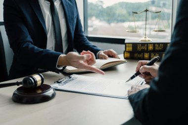 Businesswoman hand sign after Lawyer providing legal consult dispute service at the office with justice scale and gavel hammer.
