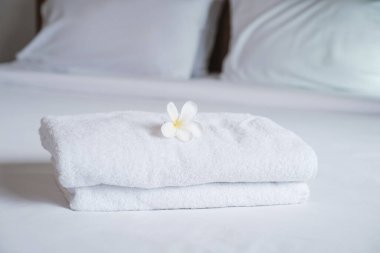 towels and Plumeria on the bed in the luxury hotel room ready for tourist travel.