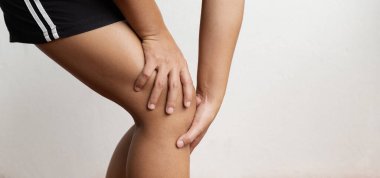 Woman hand massage physiotherapy her knee is sore and numb, exhausted, tingling. Guillain-Barre Syndrome, a side effect of the Covid vaccination.