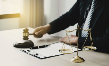 Justice scale standing in front of the lawyer providing legal consult business dispute service at the office with gavel hammer.