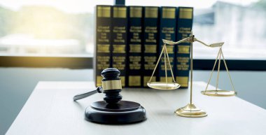 Gavel çekiç, adalet terazisi ve hukuk ders kitabı hukuk bürosunda hukuki danışmanlık hizmeti sağlamakla suçlanıyor..