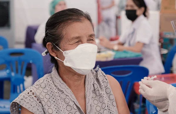Üst sınıftan bir kadın sahra hastanesinde tıbbi personelle birlikte Coronavirus aşısı yaptırmaya gitti. Hükümet tarafından kurulan bir yer..