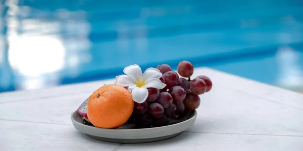 Fruits in a tray by the hotel\'s pool, healthy food concept.