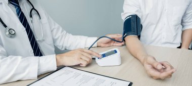 The man doctor hand use the pulse meter to measure the pressure of the patient, medical checkup concept.