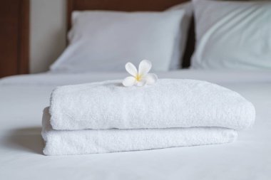 towels and Plumeria on the bed in the luxury hotel room ready for tourist travel.
