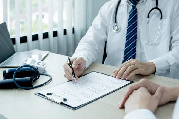 Doktor rapora işaret etti ve muayene sonuçlarını hasta adama, sağlık hizmetlerine ve sağlık kontrolüne açıkladı..