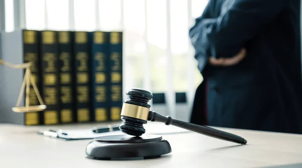 Gavel hammer, The woman lawyer is standing at the desk in the office with a justice scale. Study the law in business disputes to give advice to customers.