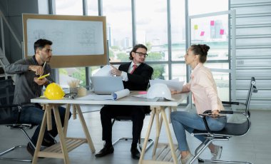 Engineer team is meeting to inspect the construction blueprint drawings, work plan and distribute work before starting the building.