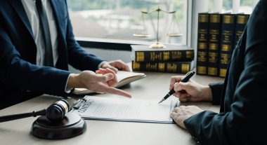 Businesswoman hand sign after Lawyer providing legal consult dispute service at the office with justice scale and gavel hammer.