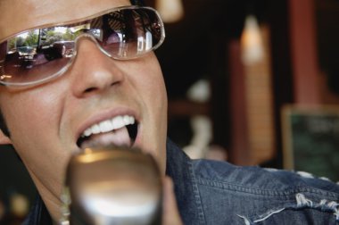 Adam mikrofona şarkı söylüyor.