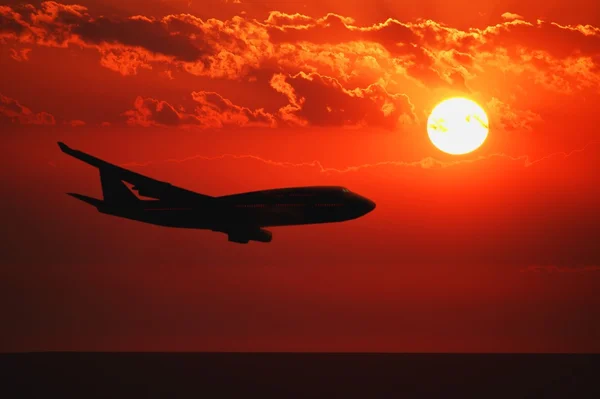 Vliegtuig vliegen tijdens zonsopgang of zonsondergang — Stockfoto