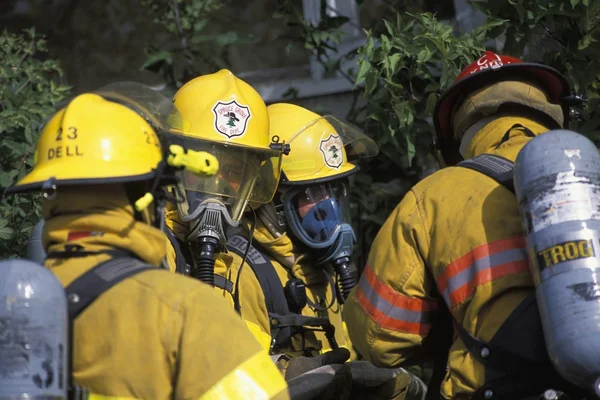 Brandweerlieden met maskers buiten gebouw — Stockfoto