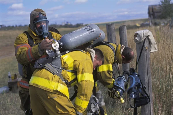 Brandweerman aanpassing van apparatuur op partner — Stockfoto