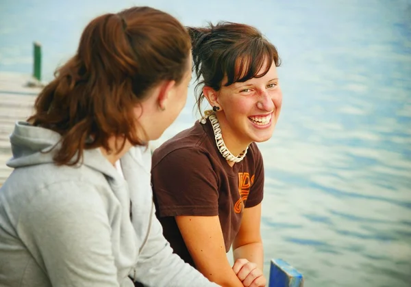 Due ragazze sedute su un molo — Foto Stock