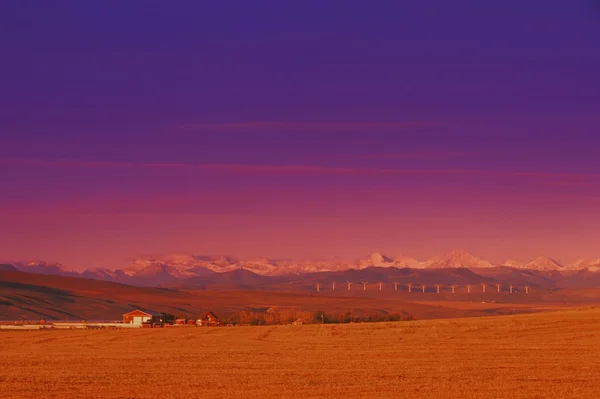 Edifícios de fazenda e campo com montanhas — Fotografia de Stock