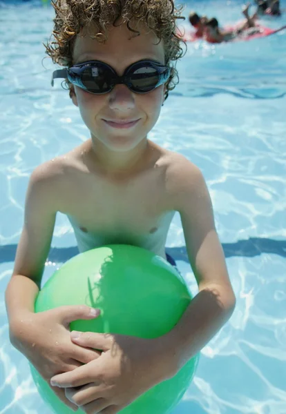 Garçon tient la balle dans la piscine — Photo