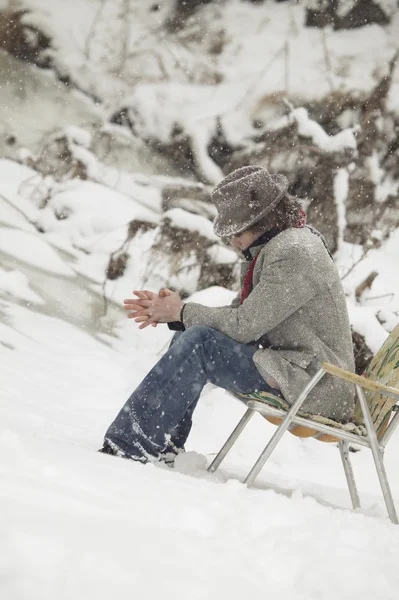 Mann sitzt in Stuhl im Schnee — Stockfoto