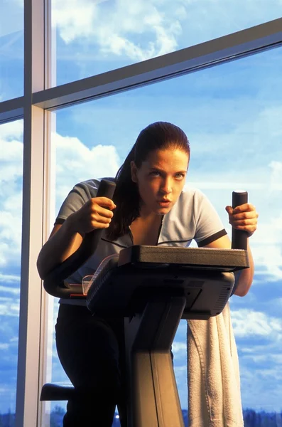 Mulher em bicicleta de exercício — Fotografia de Stock