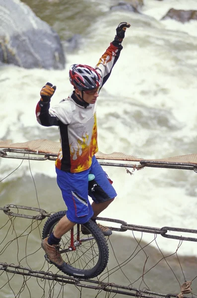 Unicyclist cruzando rio em Unicycle — Fotografia de Stock
