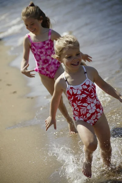 Deux enfants courent le long de la plage — Photo