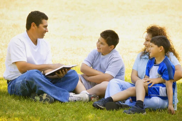 Familie hört zu, als der Vater ein Buch liest — Stockfoto